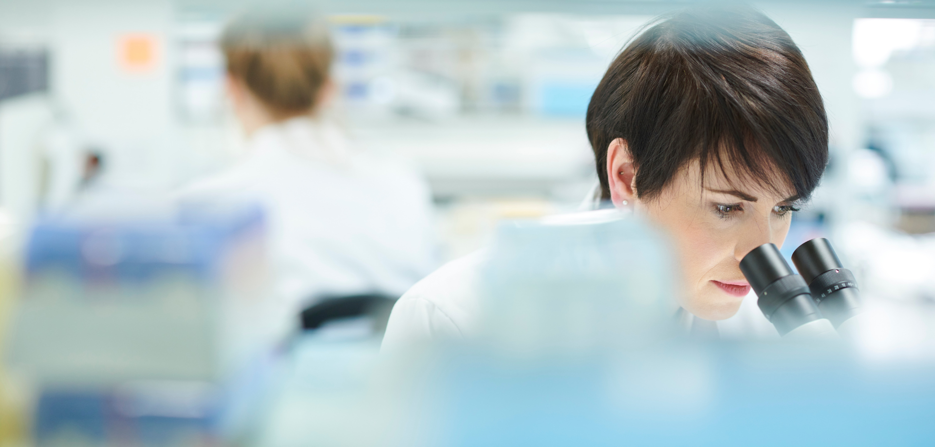A scientist looks into a microscope in a medical lab.